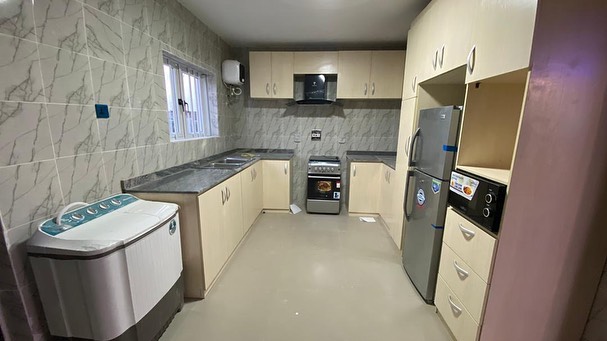 Lovely fully fitted kitchen with washing machine, heat extractor, gas cooker, fridge, and microwave of the 3 bedroom bungalow at Vantage Court, Bogije, Ajah